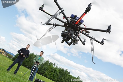 Image of Male Engineers Operating UAV Helicopter