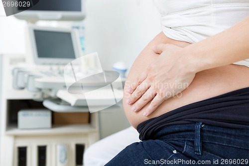 Image of Pregnant Woman Touching Her Stomach In Clinic