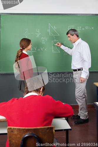 Image of Male Teacher Teaching Geometry To Girl In Classroom