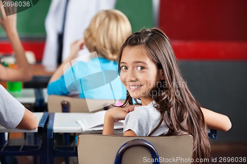 Image of Schoolgirl Sitting At Desk In Classroom