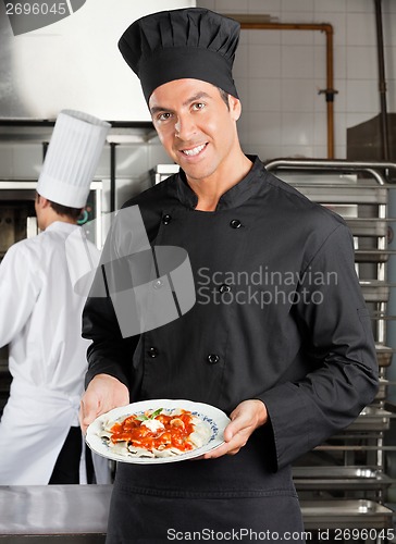 Image of Chef Presenting Dish In Kitchen