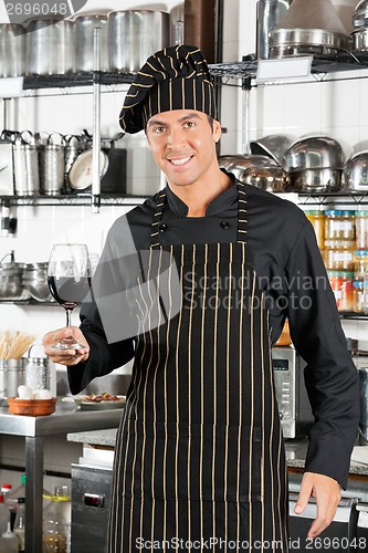 Image of Happy Chef Holding Glass Of Red Wine
