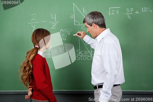 Image of Professor Teaching Mathematics To Female Student On Board