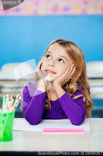 Image of Girl Looking Up While Sitting With Head In Hands In Class