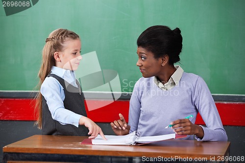 Image of Teacher Smiling While Looking At Schoolgirl