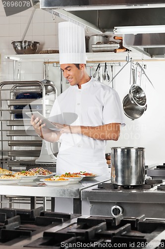 Image of Happy Chef Using Digital Tablet In Kitchen