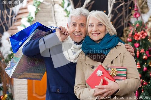 Image of Happy Couple Standing At Christmas Store