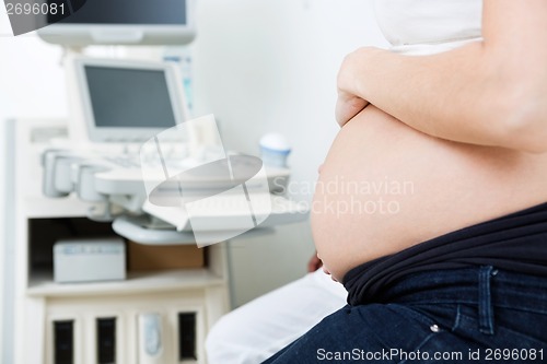 Image of Pregnant Woman With Ultrasound Machine In Background