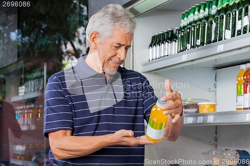 Image of Senior Male Customer Buying Juice Bottle