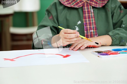 Image of Midsection Of Boy Painting At Desk