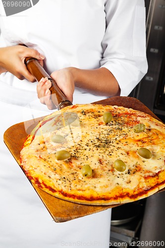 Image of Female Chef Holding Pizza On Shovel