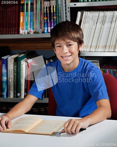 Image of Teenage Male Student Sitting At Table In Library