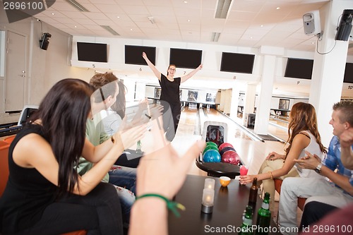 Image of Friends Applauding For Woman in Bowling Club