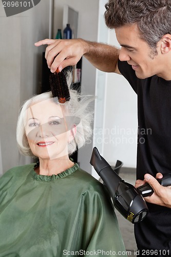 Image of Hairdresser Blow Drying Woman's Hair