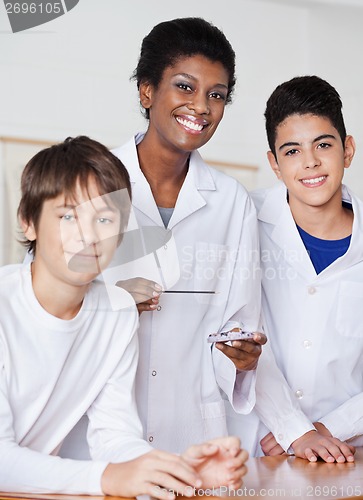 Image of Portrait Of Female Teacher With Male Students Experimenting