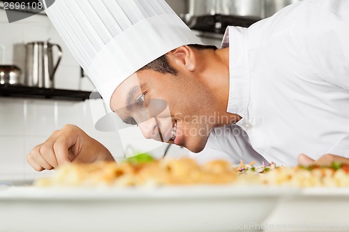 Image of Male Chef Garnishing Dish