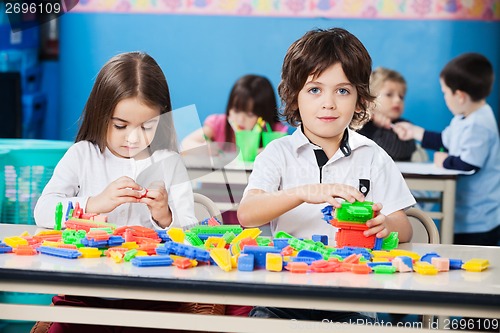 Image of Boy With Female Friend Playing Blocks In Kindergarten