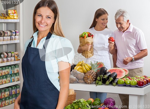 Image of Saleswoman With Family Shopping In Background