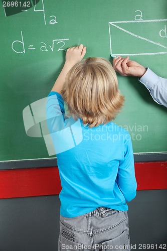 Image of Little Boy Writing Formula On Greenboard