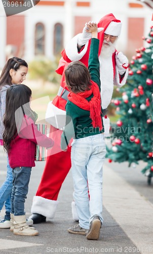 Image of Boy Giving High Five To Santa Claus