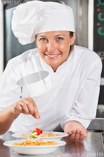 Image of Happy Chef Adding Spices To Food