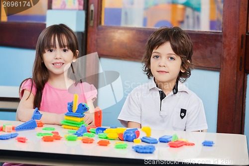 Image of Cute Friends With Construction Blocks In Kindergarten