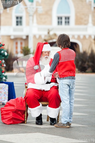 Image of Santa Claus Holding Boy's Hands