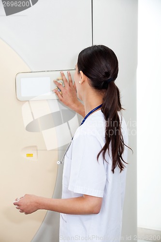 Image of Female Doctor Operating CT Scan Machine