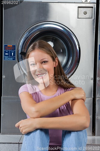 Image of Beautiful Woman Sitting Against Washing Machine