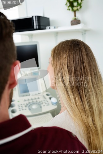 Image of Expectant Couple Looking At Ultrasound Machine