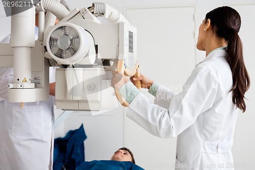 Image of Female Radiologist Performing X-ray On Patient