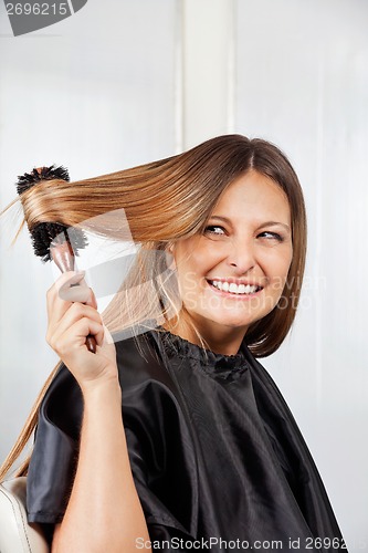 Image of Woman Brushing Hair In Salon