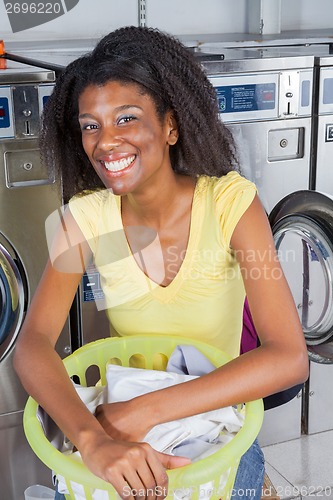 Image of Woman With Basket Of Clothes In Laundromat