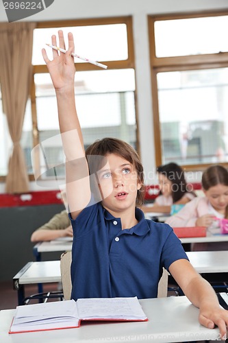 Image of Cute Schoolboy Raising Hand In Classroom