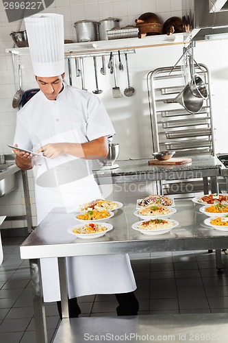 Image of Chef Using Digital Tablet In Kitchen