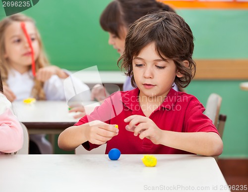 Image of Boy Molding Clay At Classroom