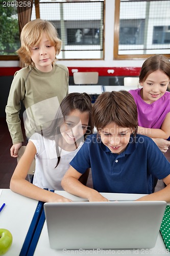 Image of Schoolchildren Using Laptop At Desk