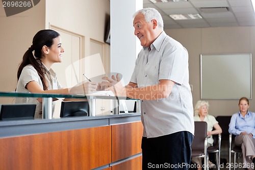 Image of Man Communicating With Female Receptionist