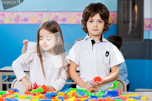 Image of Boy With Female Friend Playing Blocks In Classroom