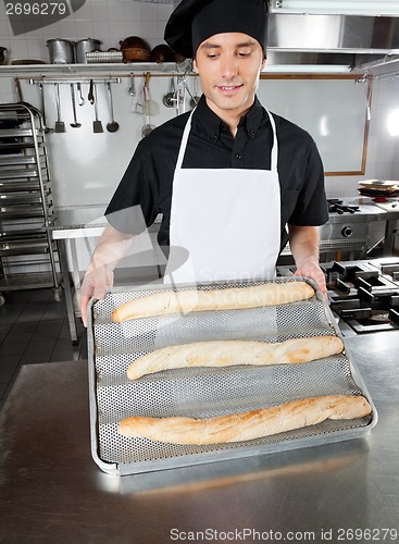 Image of Male Chef Presenting Baked Bread Loafs