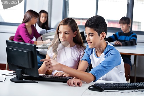 Image of Teenage Friends Using Computer In Lab