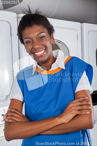 Image of Female Helper Standing With Arms Crossed In Laundry