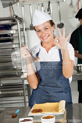 Image of Female Chef Showing Okay Sign In Kitchen