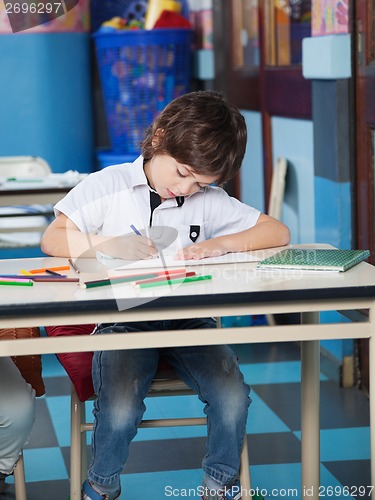 Image of Boy With Color Pencils Drawing In Classroom