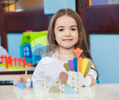 Image of Cute Girl With Craft On Desk In Classroom