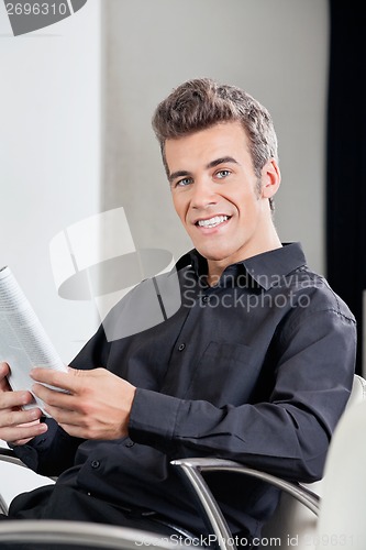 Image of Happy Customer With Book Sitting At Hair Salon