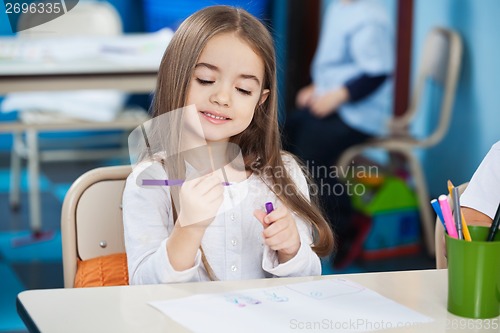 Image of Girl Looking At Sketch Pen In Classroom