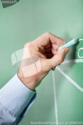 Image of Male Professor Writing On Greenboard