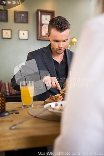 Image of Businessman Having Food With Female Colleague