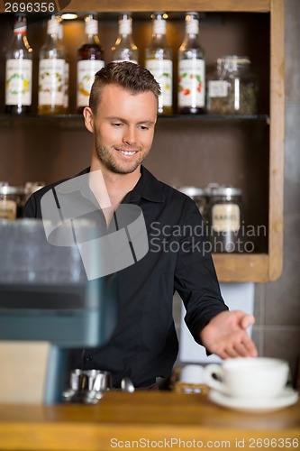 Image of Barista Gesturing At Counter In Coffeeshop